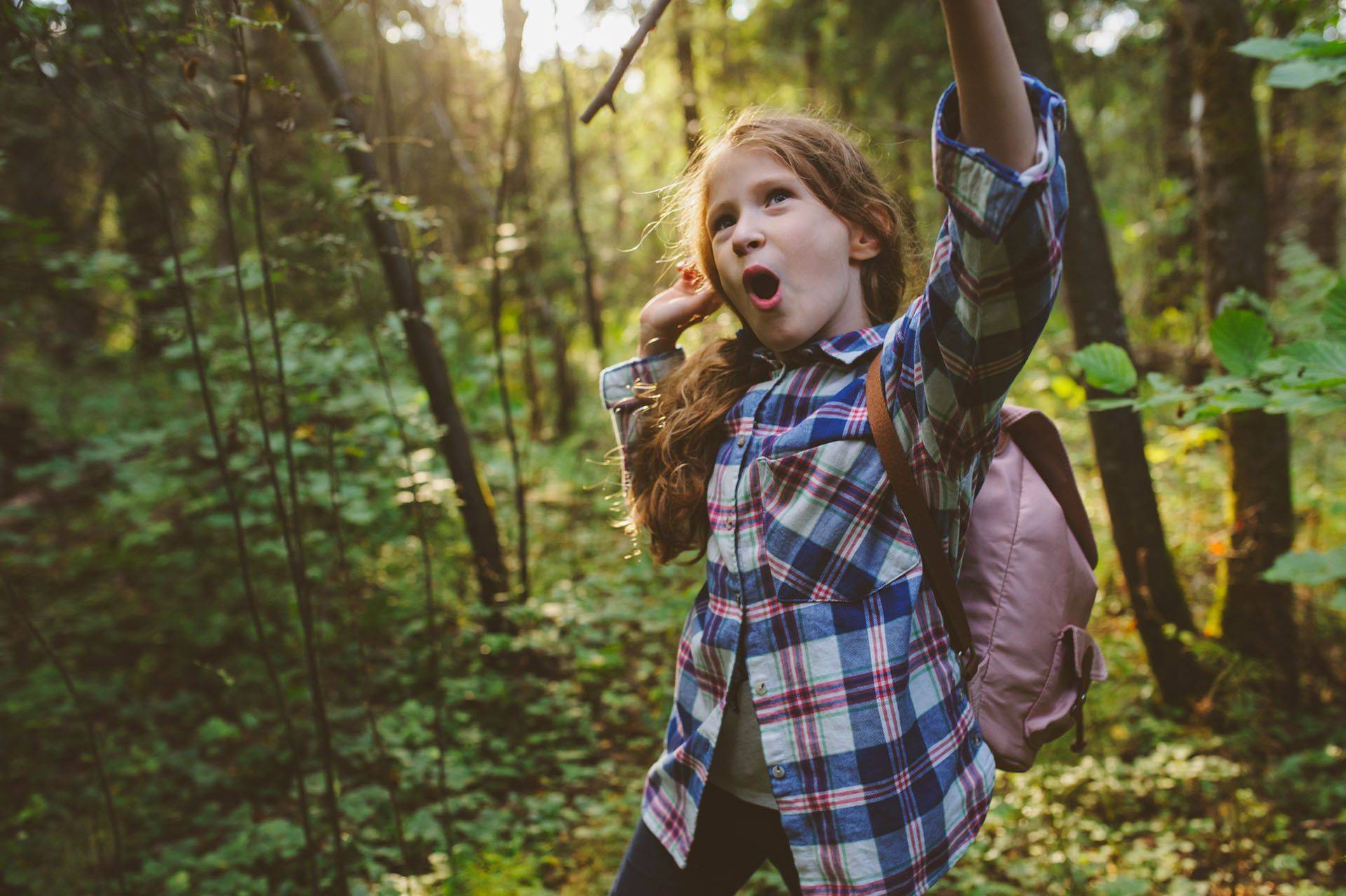 a young girl enjoying herself in the woods
