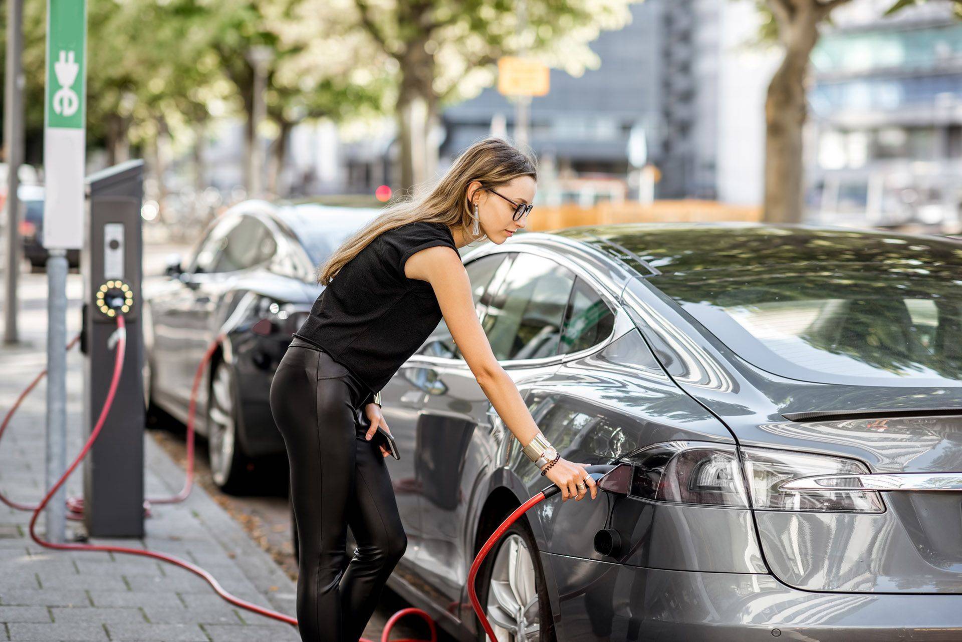 a woman charging an electric vehicle