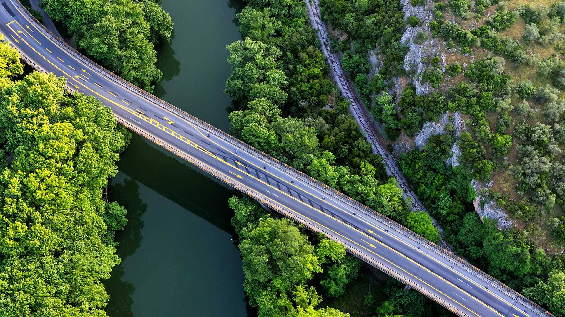 a road bridge over a river and a forest