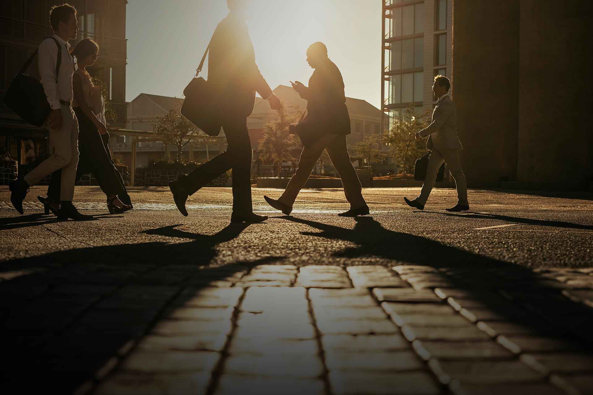 People walking on a cobbled street in the evening sun