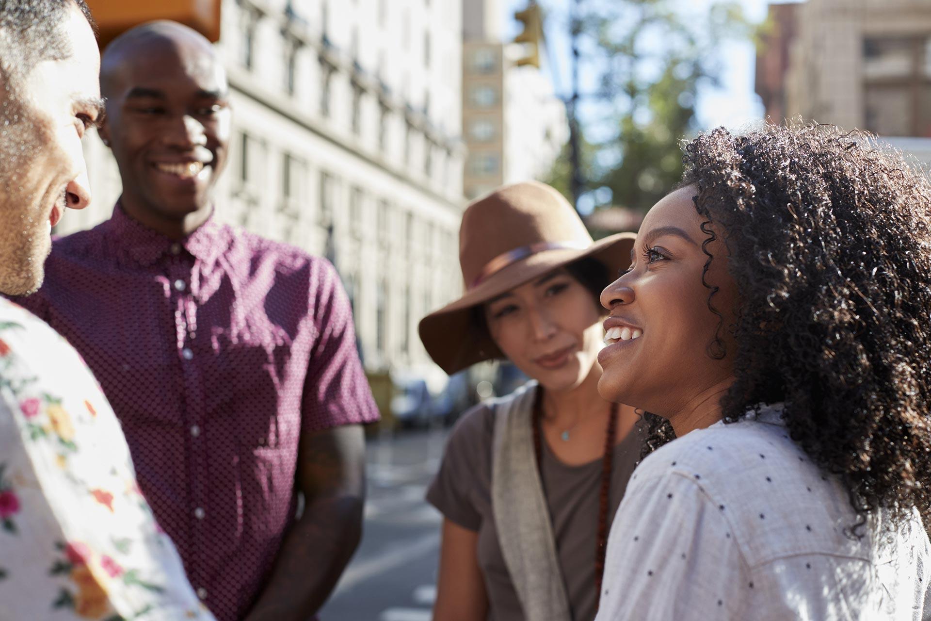 socially diverse group in discussion outside 